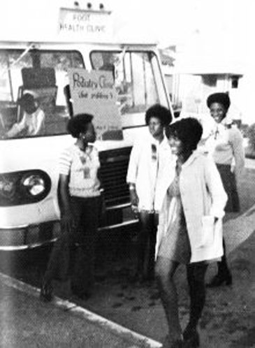 1970s era black and white photo of 4 members of Kaiser Black Student Nurses' Association standing in front of a mobile health van