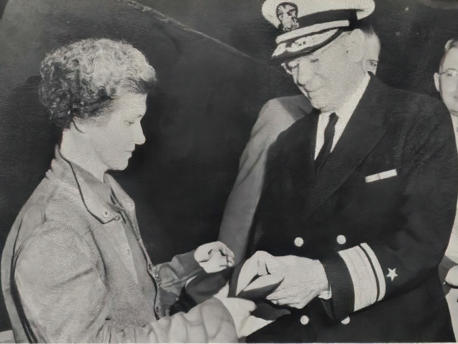 Mary Carroll accepts the Merit flag from Rear Admiral Howard L. Vickery on July 19, 1942.