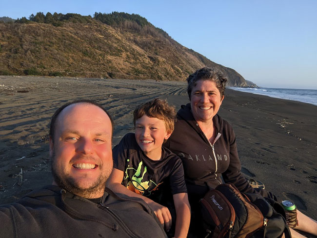 Rebecca Kucera on the beach with her husband and son