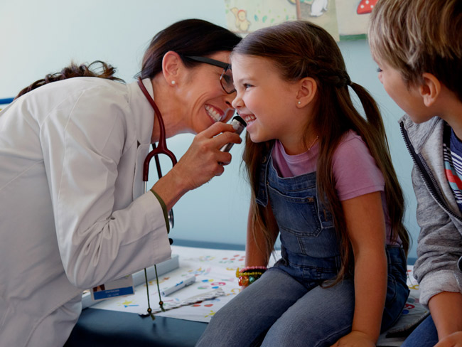 woman doctor examining a young girl patient