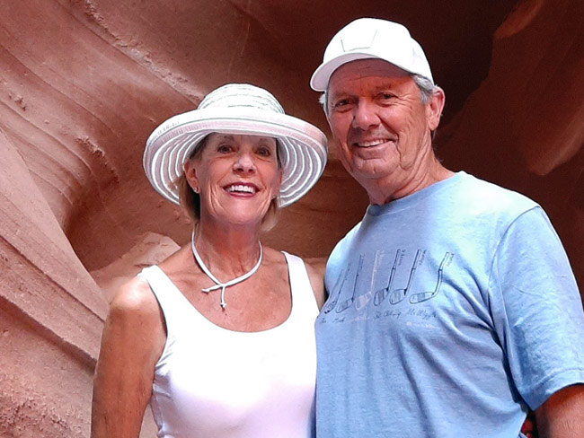 Kaiser Permanente members Robert and Dianna Binkley, posing in front of the mouth of a red cave.
