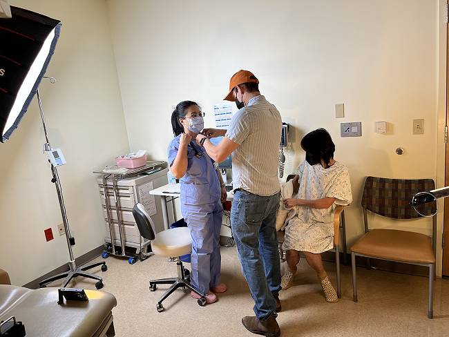 People in medical exam room with video recording equipment.