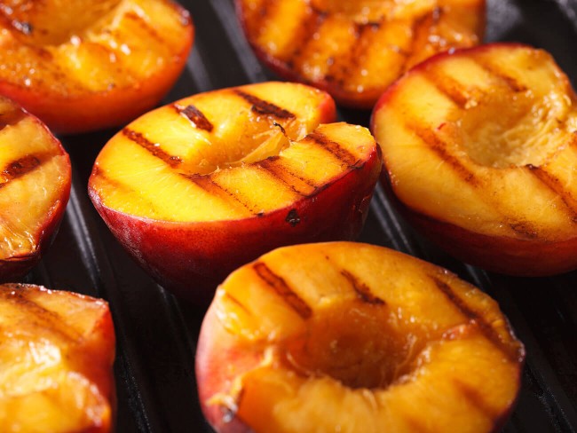 Half peaches on a grill.