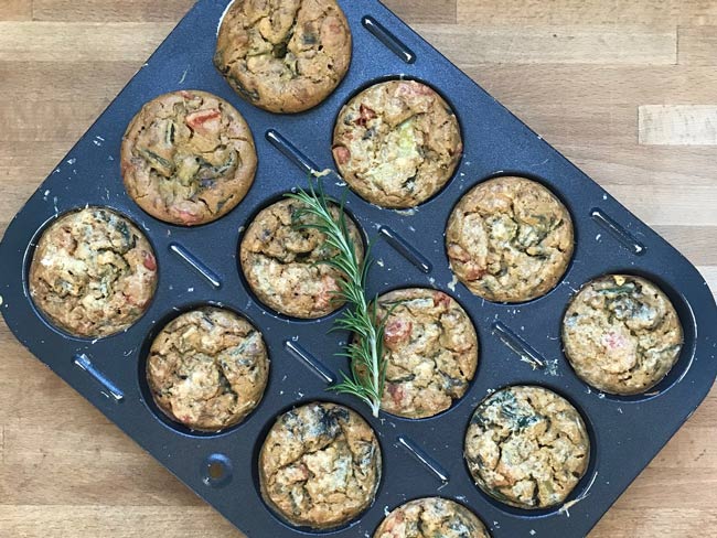 Overhead picture of spinach and tomato frittatas in muffin pan.
